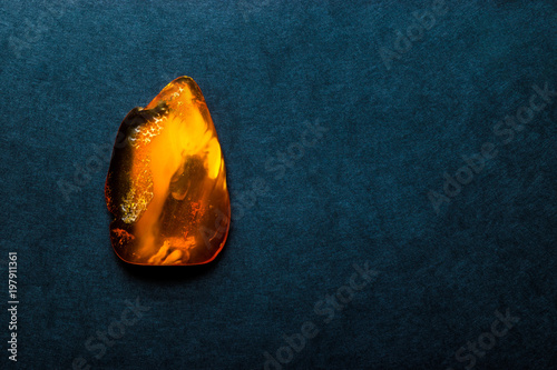 Quadro su tela Amber Stone on Dark Blue Background Surface With Free Space