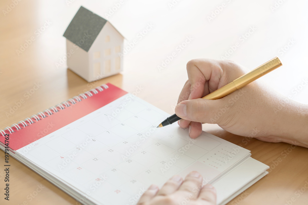 Fototapeta premium hand holding pen and marking on calendar