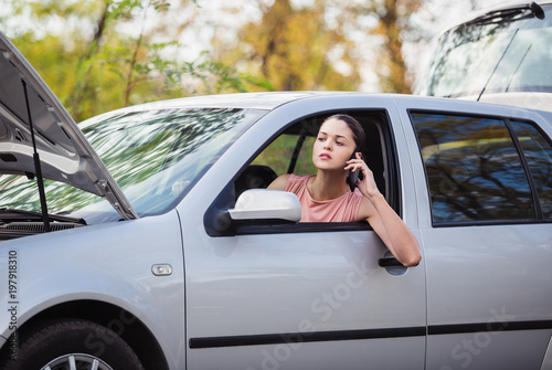Young woman calling in evacuation service. Her car broke down on the road. © artem_goncharov