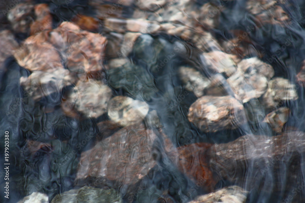 Close up of rocks under moving water.