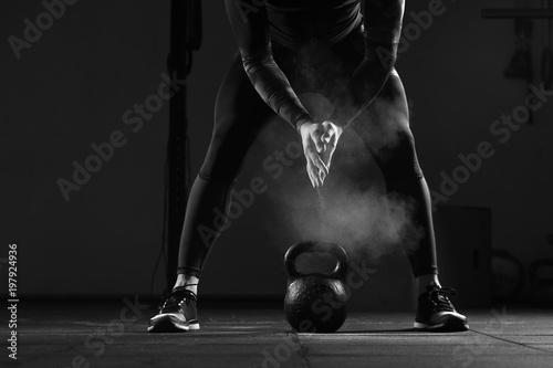 Close-up - Young muscular man working out in gym. Athletic male adult exercising with kettle bell. Fitness, sports concept.