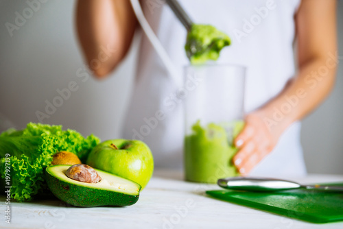 smoothie ingredients in front. woman making smoothie on background. health food concept