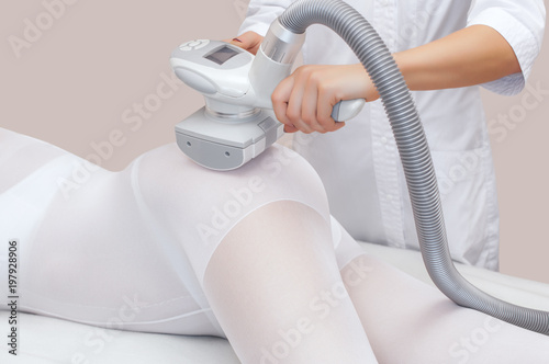 The masseur is preparing to make an  hardware anti-cellulite massage in a beauty salon. photo