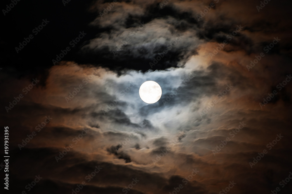 .The moon colorfully illuminates the clouds