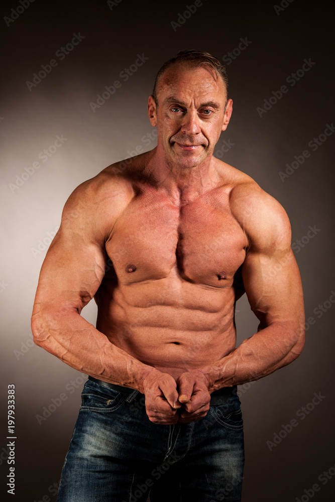 bodybuilder pose in studio over dark background bodybuilder pose in studio over dark background