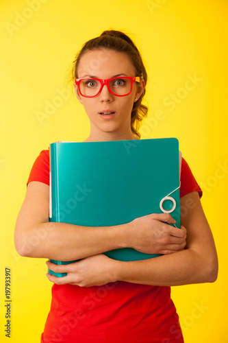 Young geek woman in red t shirt over vibrant yellow background under stress