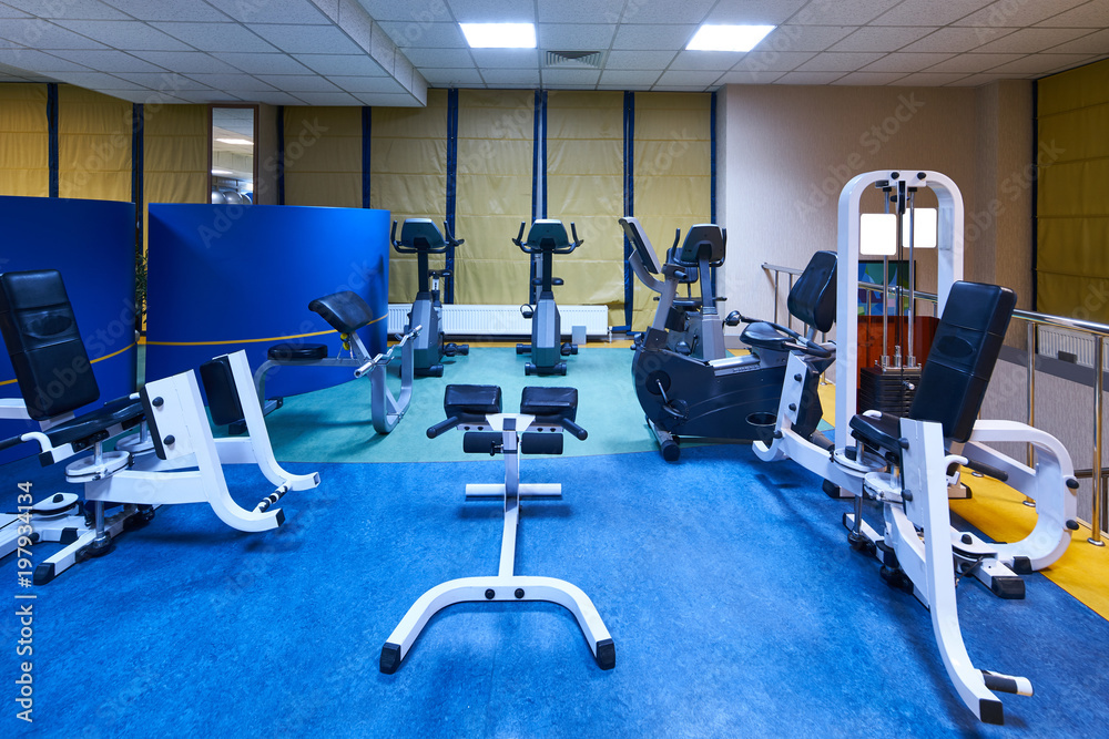 Fototapeta premium Interior of a fitness hall gym. Equipment and Machines at the Empty Modern Gym Room. Fitness Center.
