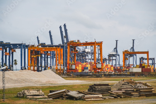 logistics, shipping concept - container and cranes at freight port