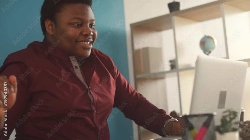 Smiling young african american man working on laptop typing in office feel happy sunlight business person internet face businessman freelance looking work slow motion black brainstorming
