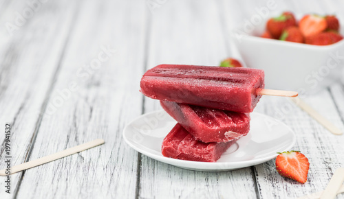 Old wooden table with homemade Strawberry Popsicles