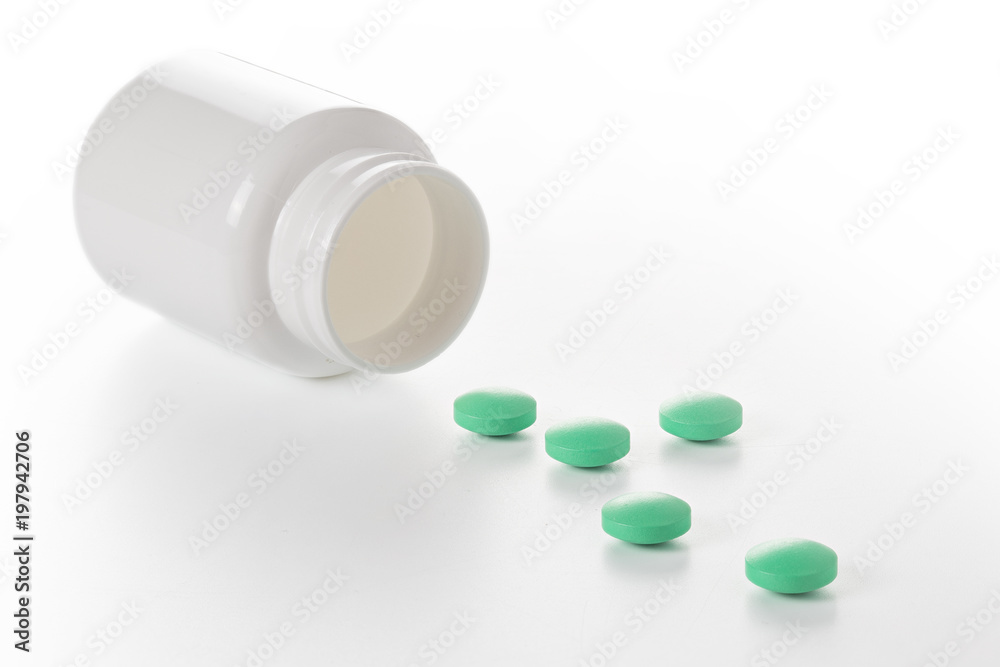 Heap of medical pills in green colors and plastic white bottle. Pills on white background. Concept of healthcare and medicine. Heap of medical pills in green colors and plastic white bottle. Pills on white background. Concept of healthcare and medicine.