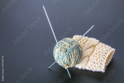 A ball of wool with knitting needles and socks on a gray table. Needlework. photo