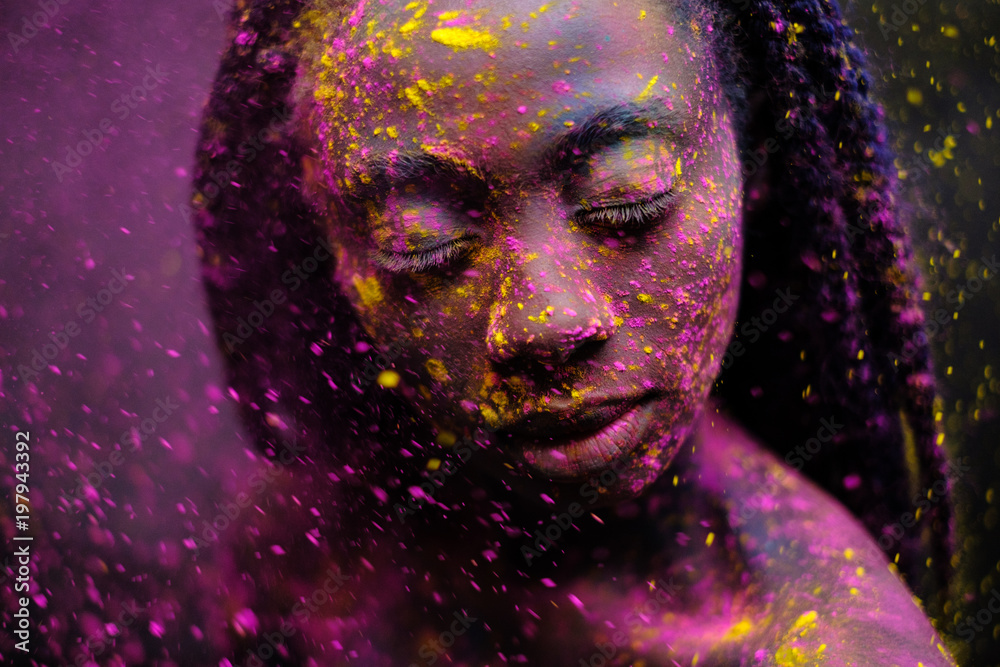 African woman with colourful powder on her face and body. - obrazy, fototapety, plakaty 