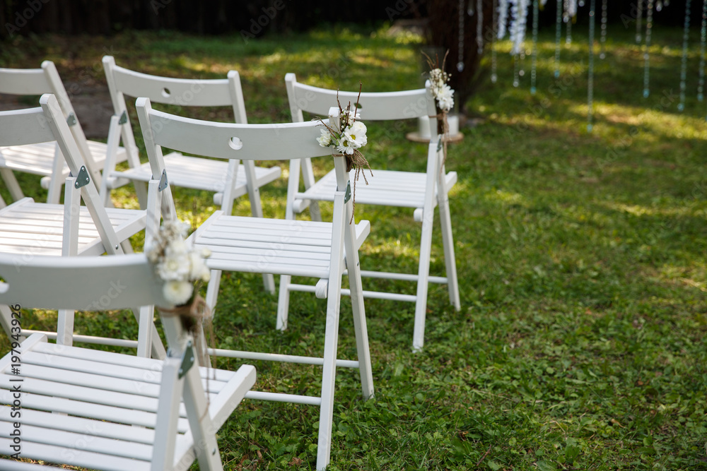 Chairs with wedding decor for guests at wedding ceremony