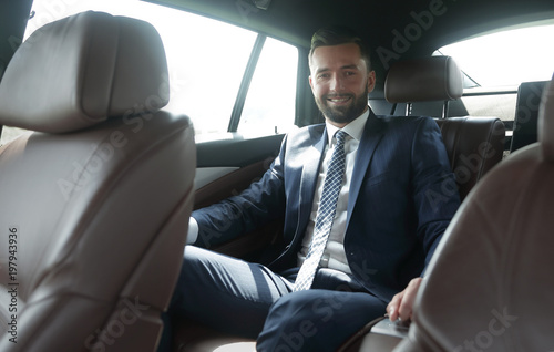 businessman sitting in the back seat of a car © ASDF