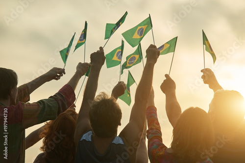 Rising up brazil flags. Crowd of people holding brazilian flags, back view. photo