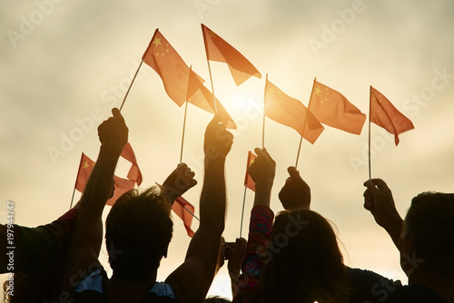Canvas Print Silhouette of people holding chineese flags