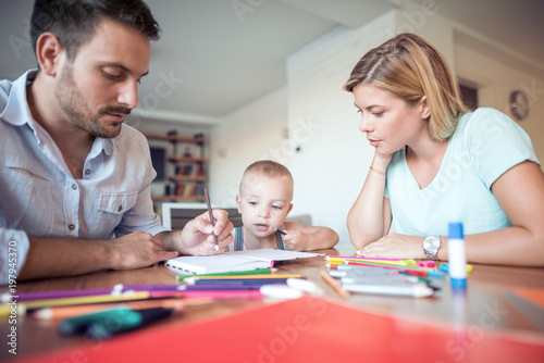 Young parent and son drawing in the living room