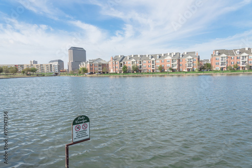 Typical water view apartment building complex at Lake Carolyn, Las Colinas, Irving, Texas. Cloud blue sky.