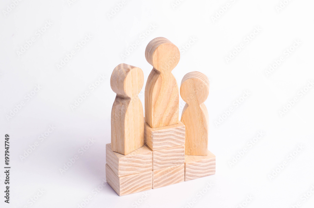 Three wooden figures of a man stand on the podium of the winners. The concept of victory, business competition and competition among employees. Olympiad and Paraolympic Games, Universiade. Three wooden figures of a man stand on the podium of the winners. The concept of victory, business competition and competition among employees. Olympiad and Paraolympic Games, Universiade.