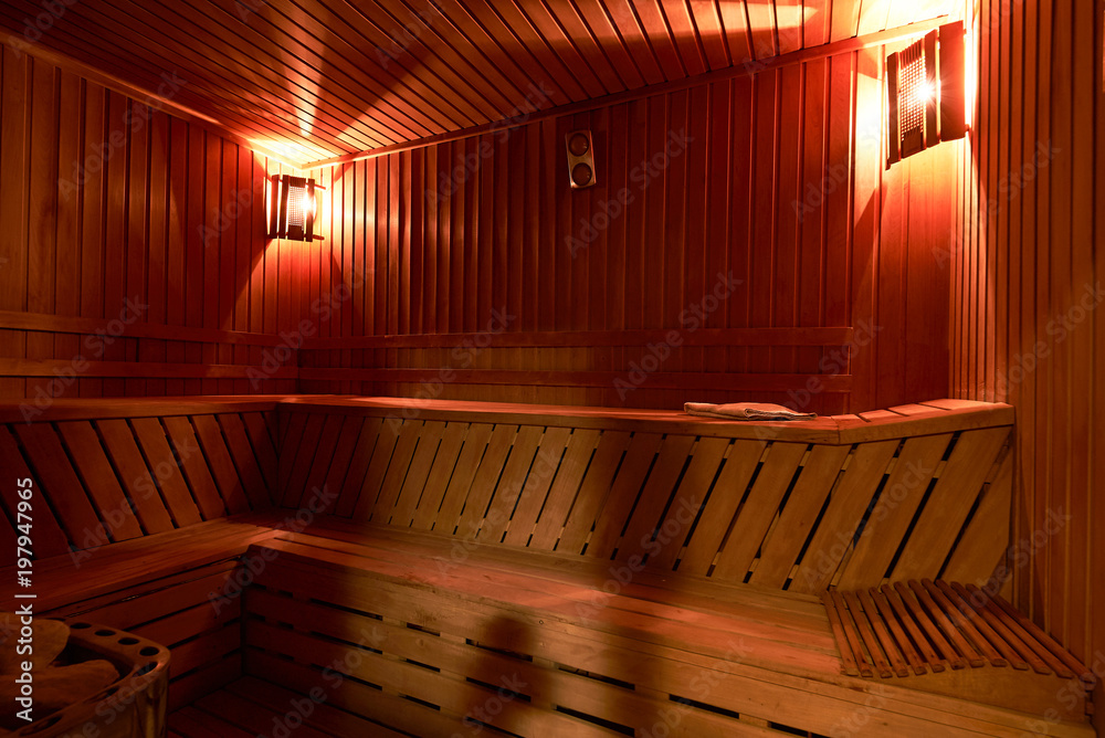 Wooden sauna interior. Relax in a hot small Finnish wooden sauna room in SPA centre Wooden sauna interior. Relax in a hot small Finnish wooden sauna room in SPA centre