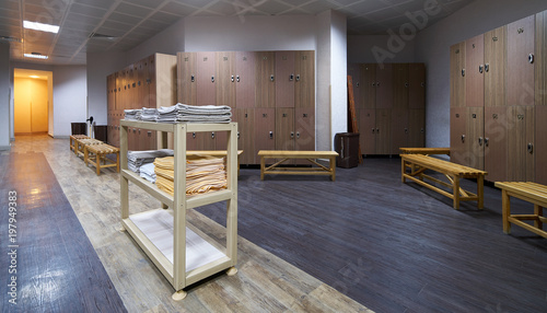 Quadro su tela Clean towels shelf in a locker room with wooden benches in luxury fitness gym