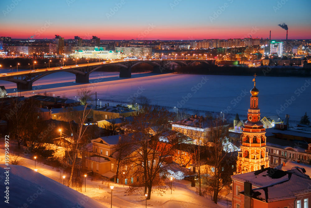 Night dusk cityscape panorama view of Nizhny Novgorod at winter, Russia. Kanavino Bridge over Oka River