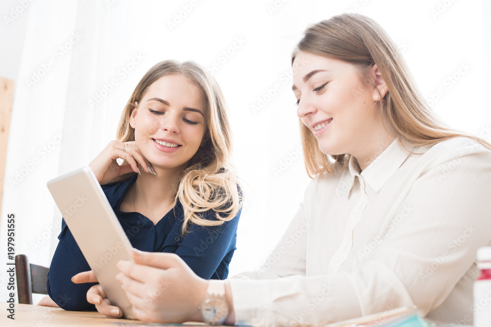Two businesswomen using digital tablet at office Two businesswomen using digital tablet at office