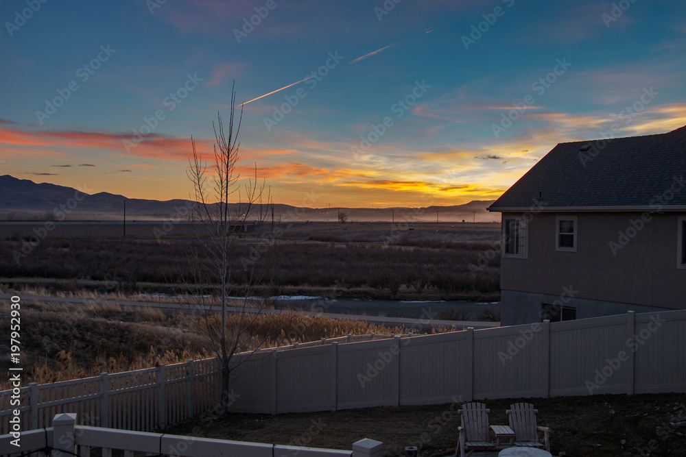 Stunning sunset looking off a house deck beyond the river and mountains