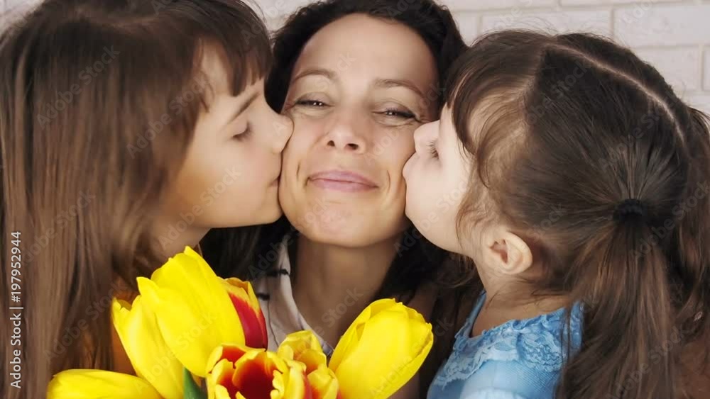 Mothers Day. Daughters kiss mother. Mothers Day. Daughters kiss mother.