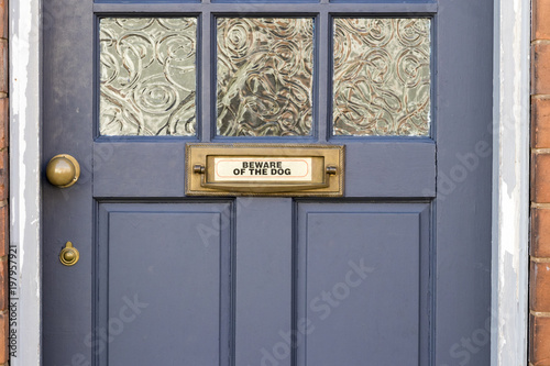 Beware of the dog sign on a blue front door with a letterbox