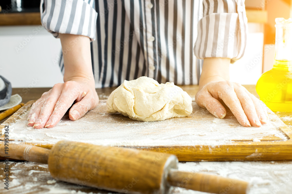 Female hands making dough on kitchen background Female hands making dough on kitchen background