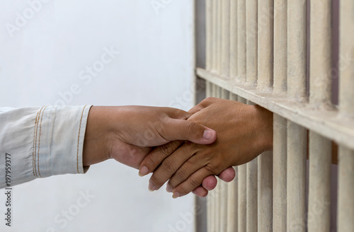 Hold hands with a female friend in a prison.