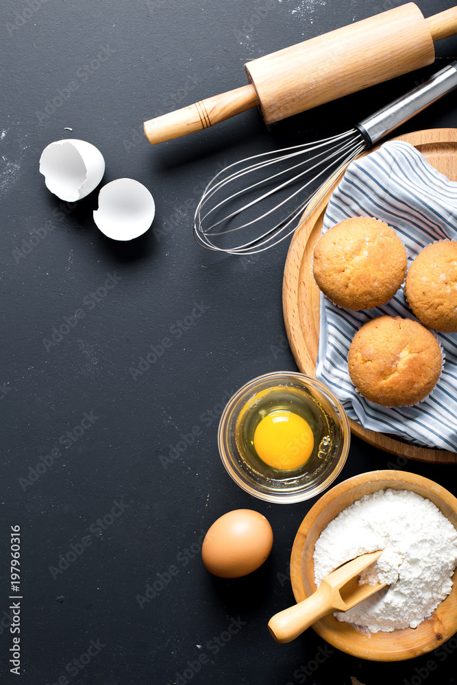 Baking ingredients. Bowl, eggs, flour, eggbeater, rolling pin and eggshells on black chalkboard from above. Baking ingredients. Bowl, eggs, flour, eggbeater, rolling pin and eggshells on black chalkboard from above.