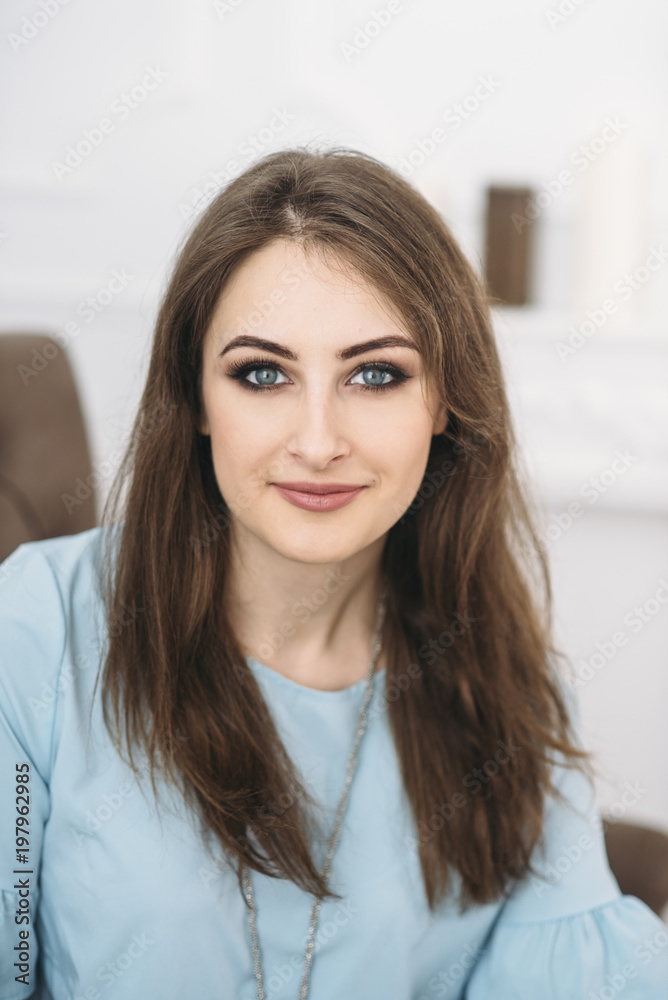 beautiful young stylish woman is sitting on the sofa portrait