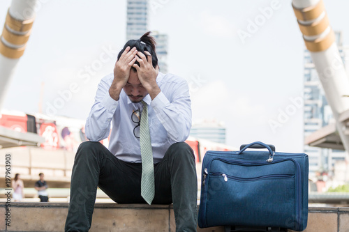 Tired or stressful businessman sitting sadly on the stairs after working photo