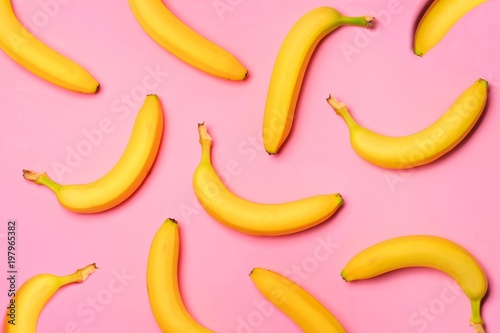 Colorful fruit pattern with bananas over a pink background. Top view.