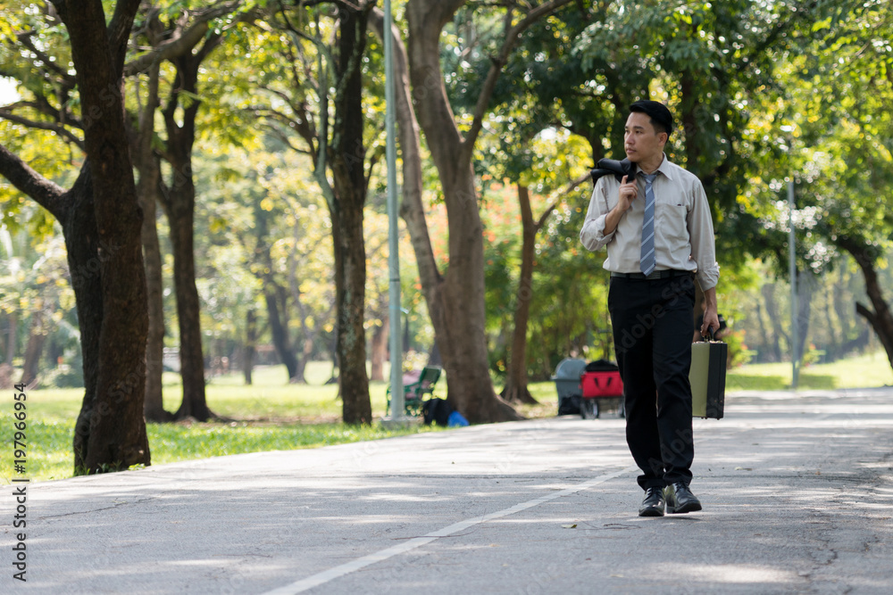 Young Asia businessman showing stress face. He was walking in the Park..