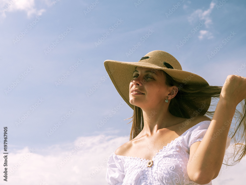 Girl in hat on sky background