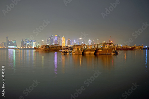 Traditional Dhows in front of nightly Doha Skyline