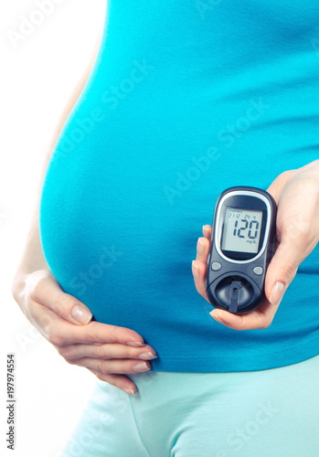 Woman in pregnant holding glucose meter with result of sugar level, diabetes during pregnancy