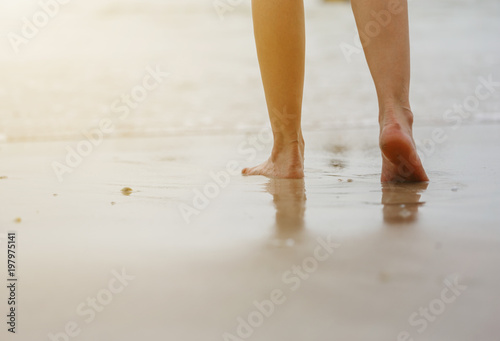 Close up of female legs walking on beach