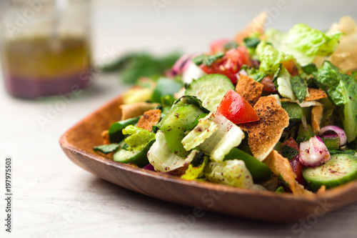 Healthy fattoush salad closeup. The key ingredient in this middle eastern dish is the toasted pita bread which is mixed with healthy vegetables, herbs and a dressing made with lemon and sumac.