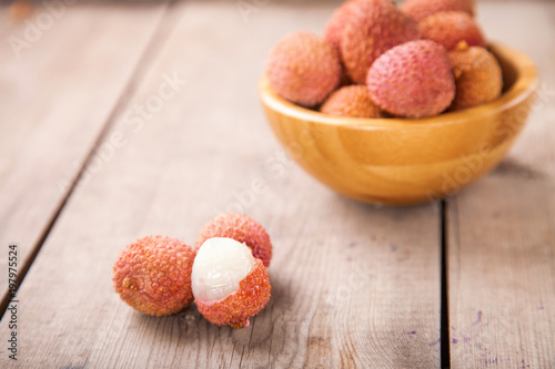Fruits lychee in a bowl on a wooden background. Selective focus. Copy space.