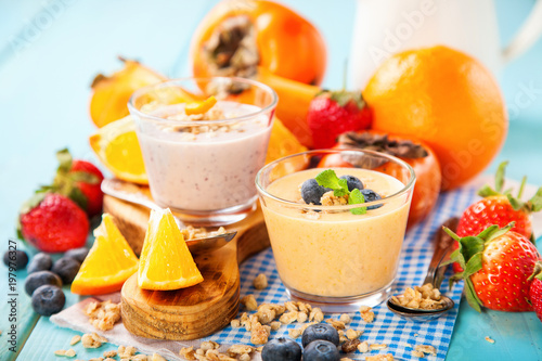 Orange persimmon blueberry smoothie with granola and fruits. Selective focus. Copy space