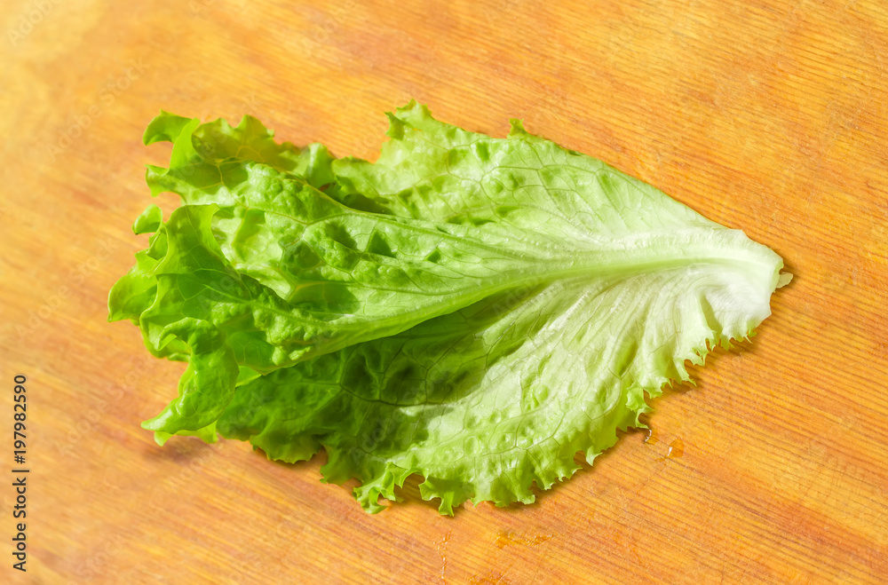 Lettuce leaf on the wooden cutting board Lettuce leaf on the wooden cutting board