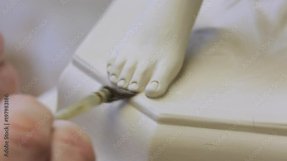 The work of the master to remove excess material on the porcelain figure. The work of the master to remove excess material on the porcelain figure.
