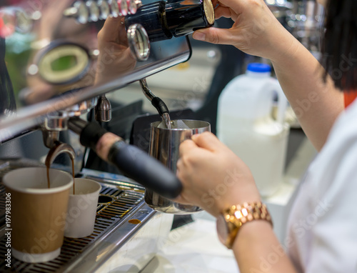 Barista hand adjusting level of steam pressure for milk frothing for espresso shot