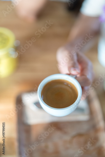 Hot espresso coffee on women hand holder
