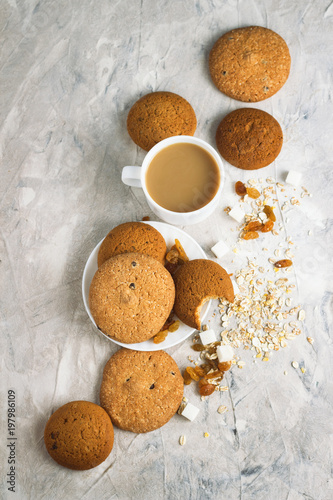 Cup of Coffee with Milk, Cookies, Raisins, Oat Flakes on a light background. Top view